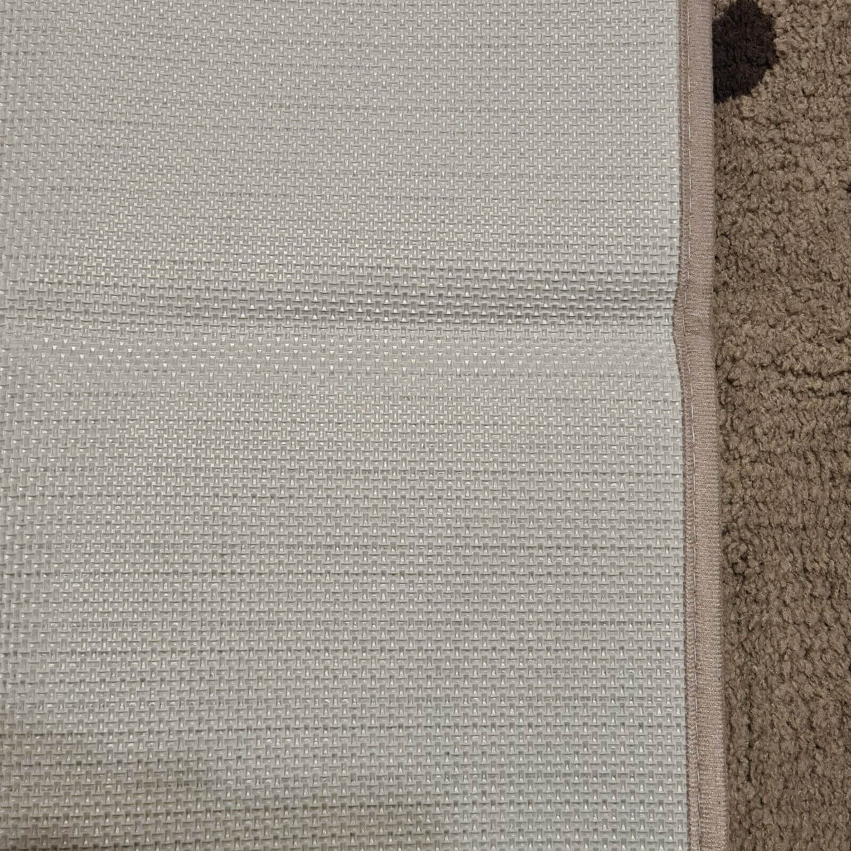 Close-up of PURRUGS grey indoor door mat with black paws, showcasing texture and edge detail.