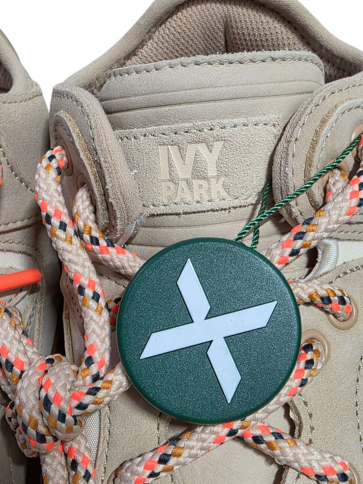 Close-up of Adidas Ivy Park Top Ten 2000 shoe laces and logo tag, showcasing intricate details and design.