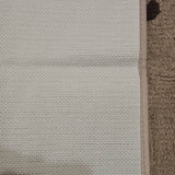 Close-up of PURRUGS grey indoor door mat with black paws, showcasing texture and edge detail.