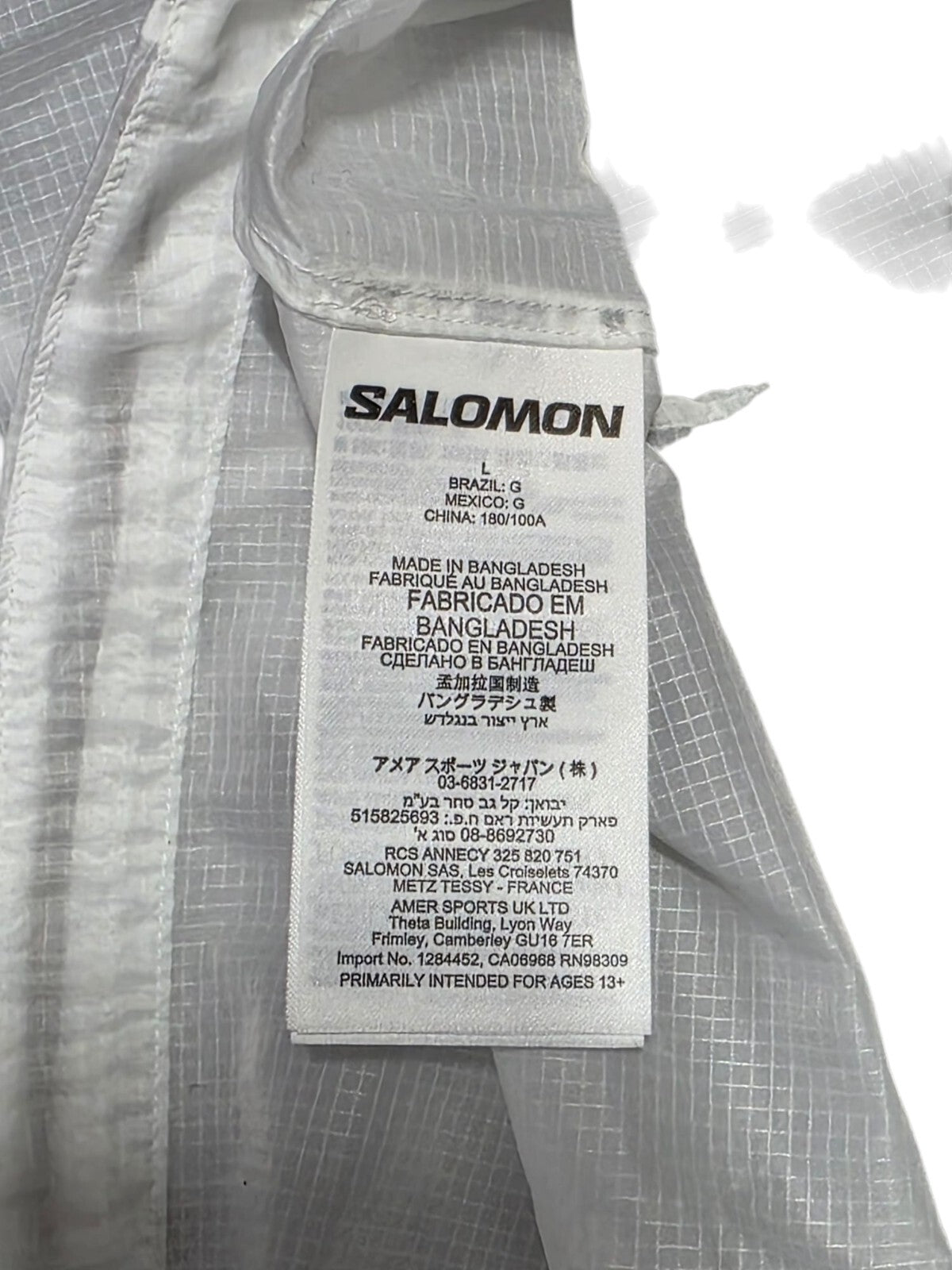 Salomon men’s vest care label showing manufacturing details and size information, designed for running enthusiasts.