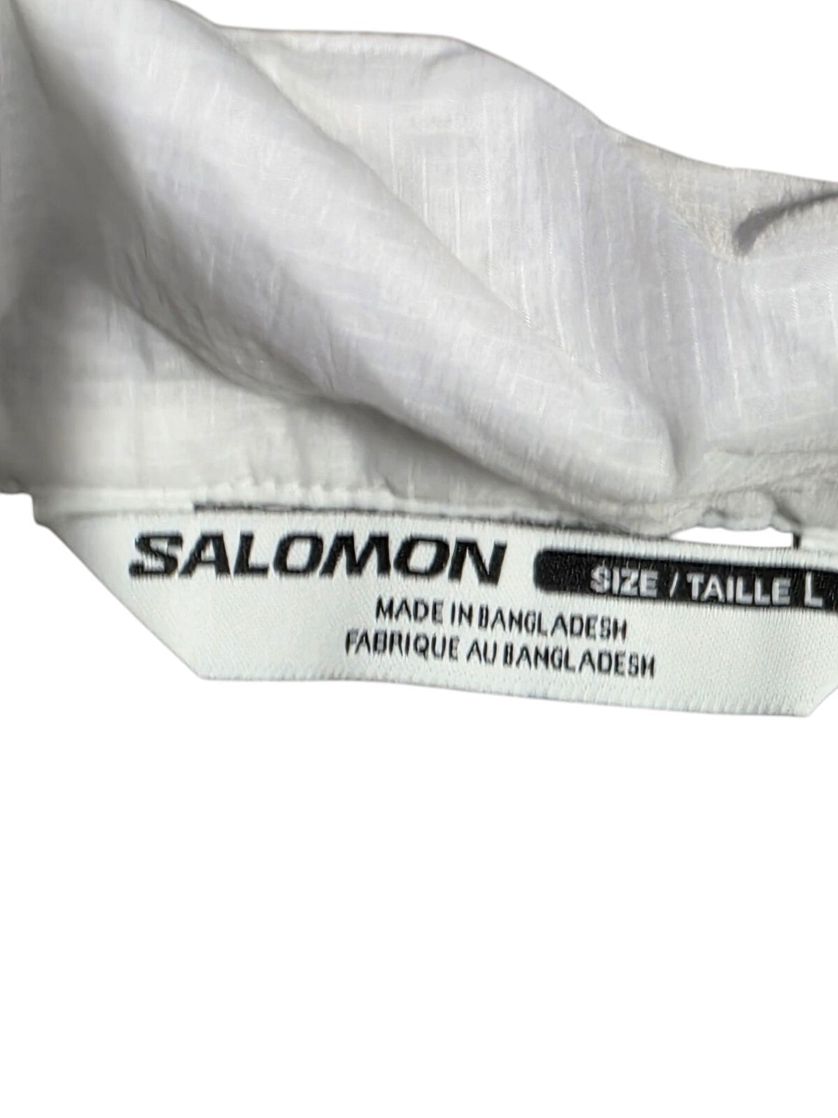 Salomon vest size label showing L for large, made in Bangladesh, part of lightweight running apparel.